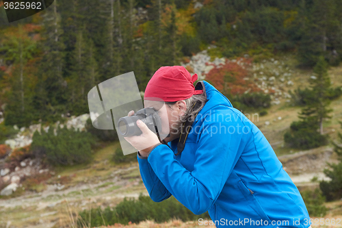 Image of hiking man in nature taking photo