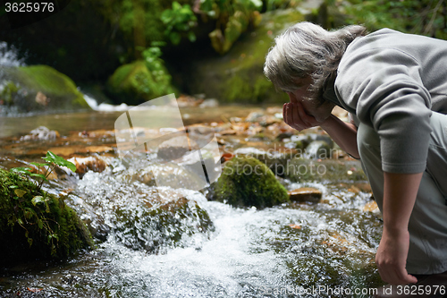 Image of man drinking fresh water from spring