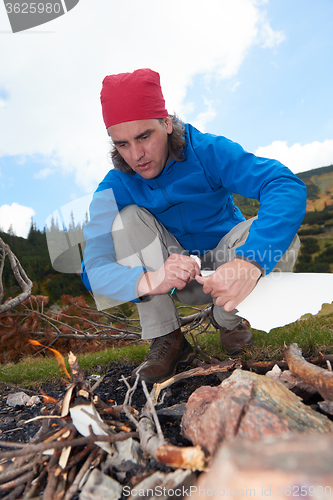 Image of hiking man try to light fire