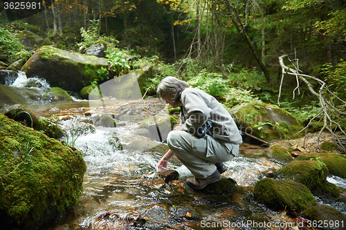 Image of man drinking fresh water from spring