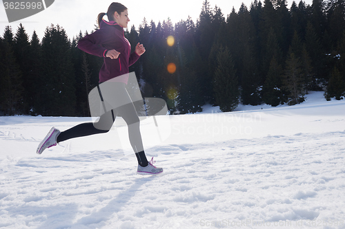 Image of yougn woman jogging outdoor on snow in forest