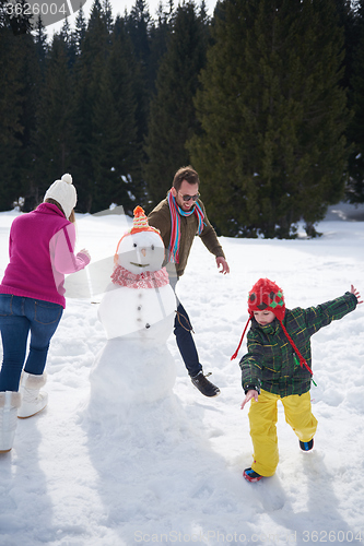 Image of happy family building snowman