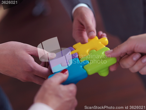 Image of business people group assembling jigsaw puzzle