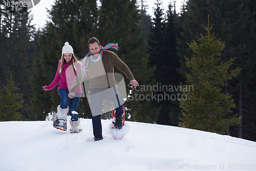 Image of couple having fun and walking in snow shoes