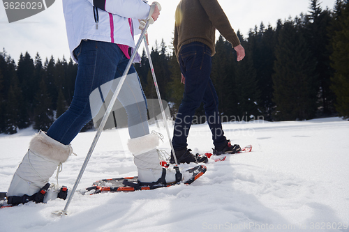 Image of couple having fun and walking in snow shoes