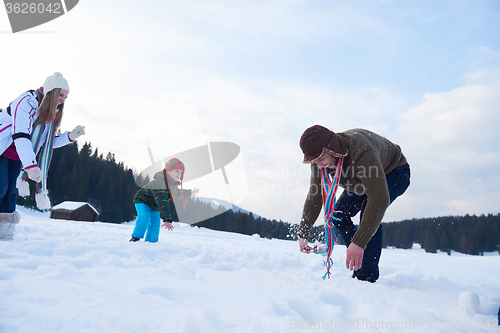 Image of happy family playing together in snow at winter