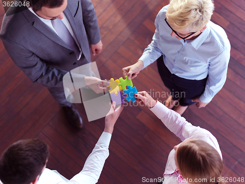 Image of business people group assembling jigsaw puzzle