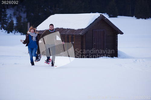 Image of couple having fun and walking in snow shoes