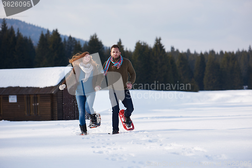 Image of couple having fun and walking in snow shoes