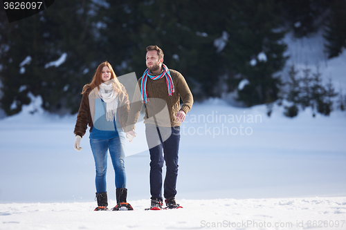 Image of couple having fun and walking in snow shoes