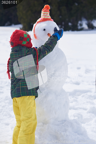 Image of boy making snowman