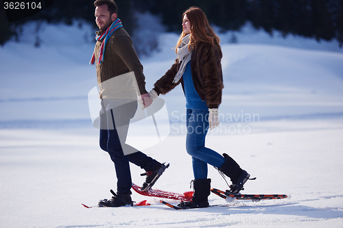 Image of couple having fun and walking in snow shoes