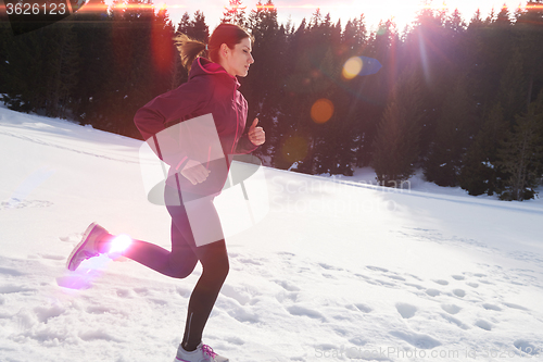 Image of yougn woman jogging outdoor on snow in forest