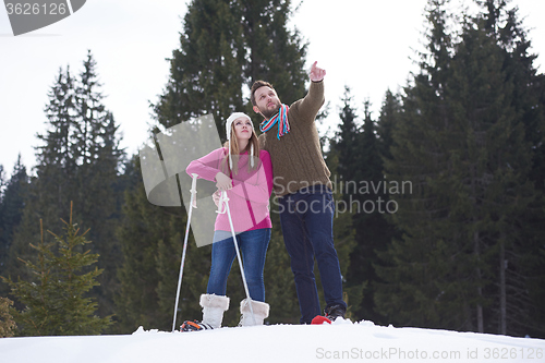 Image of couple having fun and walking in snow shoes