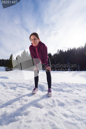 Image of yougn woman jogging outdoor on snow in forest