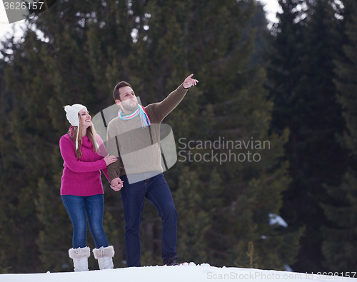 Image of couple having fun and walking in snow shoes