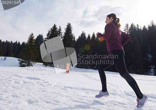 Image of yougn woman jogging outdoor on snow in forest