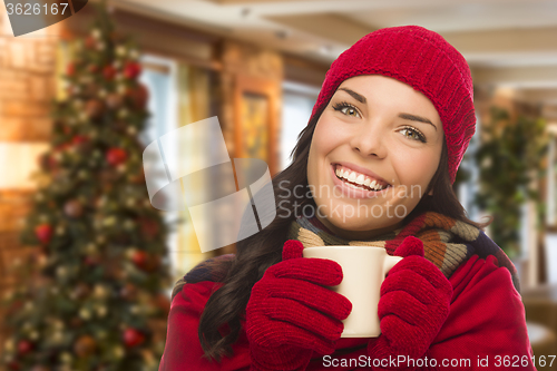 Image of Mixed Race Woman Wearing Hat and Gloves In Christmas Setting