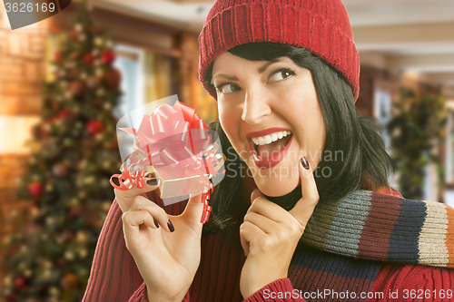 Image of Woman Holding Wrapped Gift in Christmas Setting