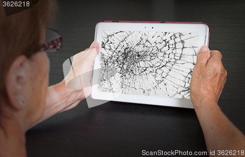 Image of Senior lady with tablet, cracked screen