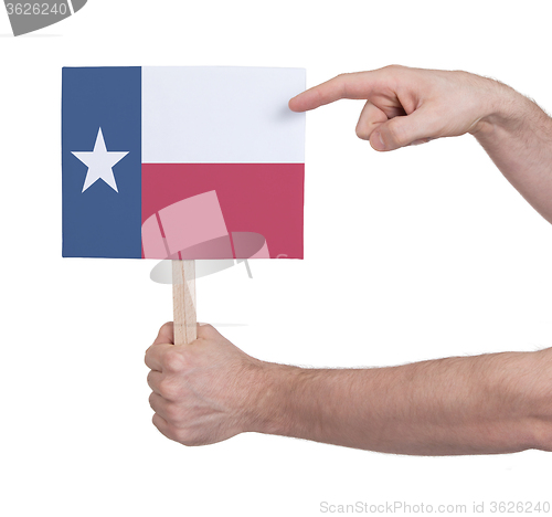 Image of Hand holding small card - Flag of Texas
