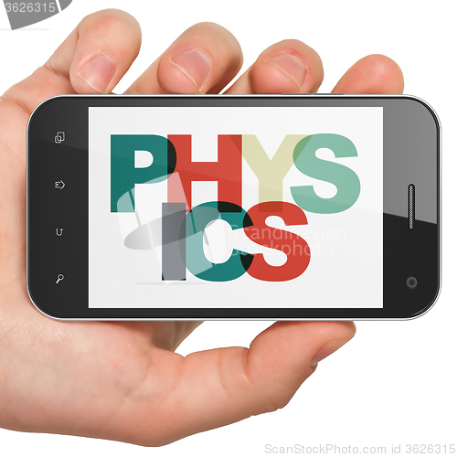 Image of Studying concept: Hand Holding Smartphone with Physics on  display