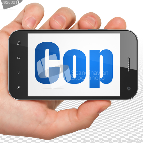 Image of Law concept: Hand Holding Smartphone with Cop on display