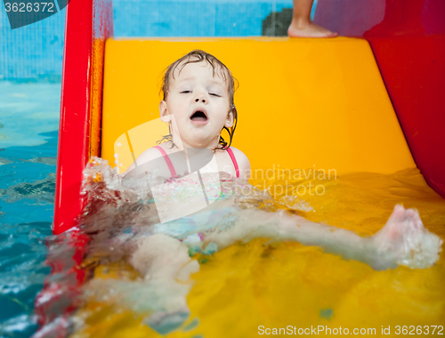 Image of Pretty little girl rides from hill in aquapark