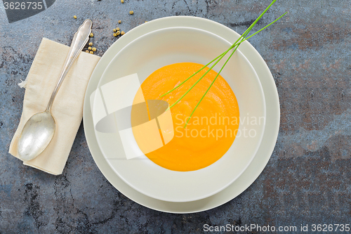 Image of Delicious healthy pumpkin soup, spoon and napkin