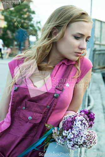 Image of Pretty sad woman holding bouquet