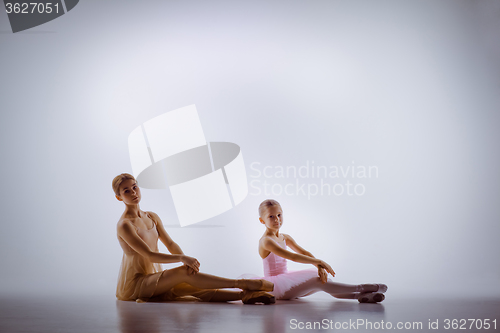 Image of The little ballerina posing with personal teacher in dance studio