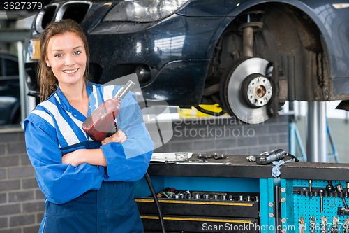 Image of Mechanic With Pneumatic Wrench Standing By Car