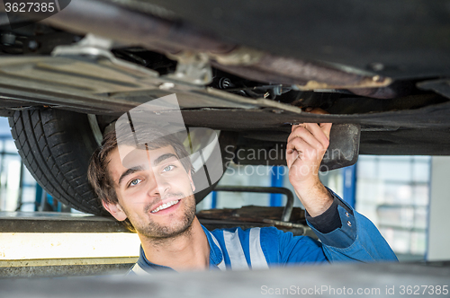 Image of Smiling Female Mechanic Holding Car Tire