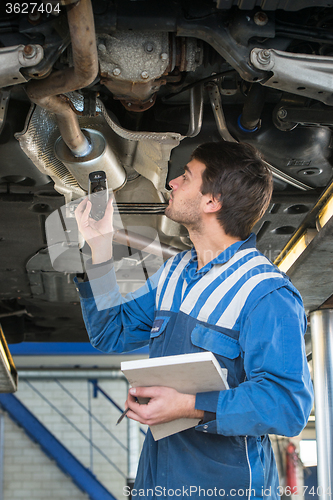 Image of Mechanic checking an exhaust for gas leaks