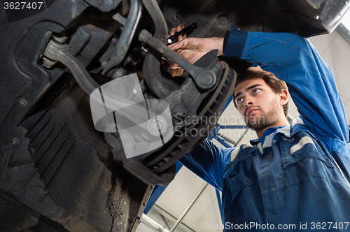 Image of Mechanic Repairing Car In Automobile Shop