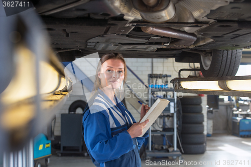 Image of Mechanic underneath a car during a periodic examination