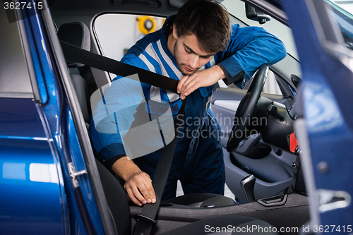 Image of Mechanic Examining Car Seat Belt