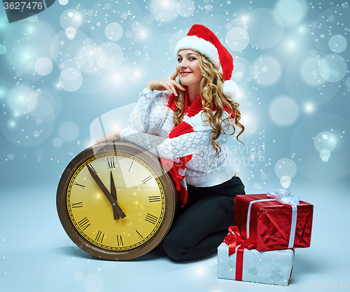 Image of Girl dressed in santa hat holding with a Christmas decorations  