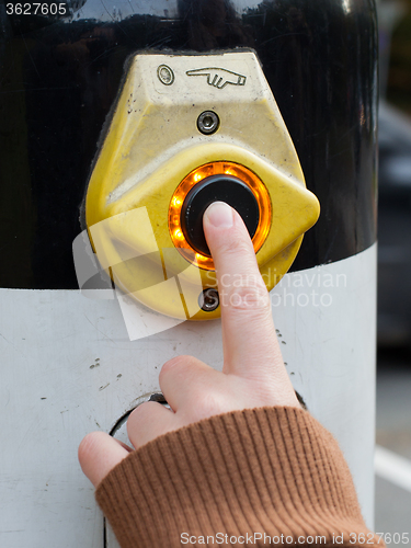 Image of Hand pushing button for traffic light