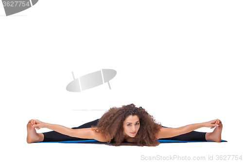 Image of Studio shot of a young fit woman doing yoga exercises.