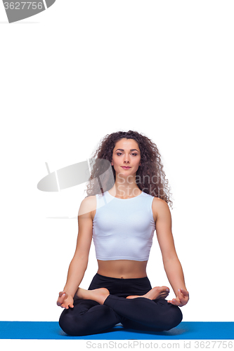 Image of Studio shot of a young fit woman doing yoga exercises.