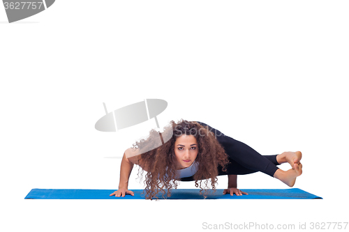 Image of Studio shot of a young fit woman doing yoga exercises.