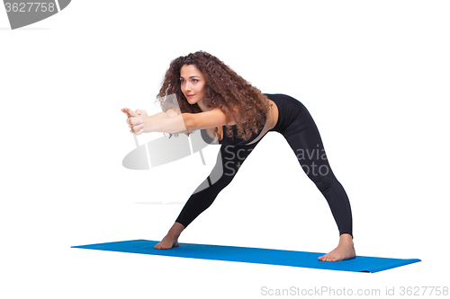 Image of Studio shot of a young fit woman doing yoga exercises.
