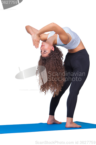 Image of Studio shot of a young fit woman doing yoga exercises.