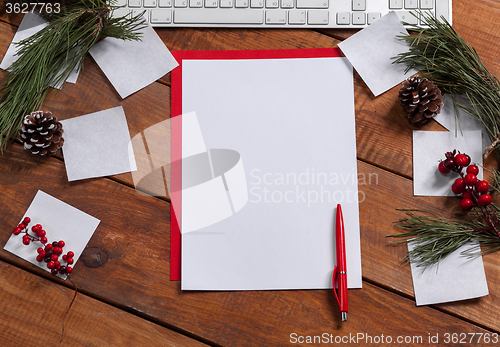 Image of The blank sheet of paper on the wooden table with a pen 