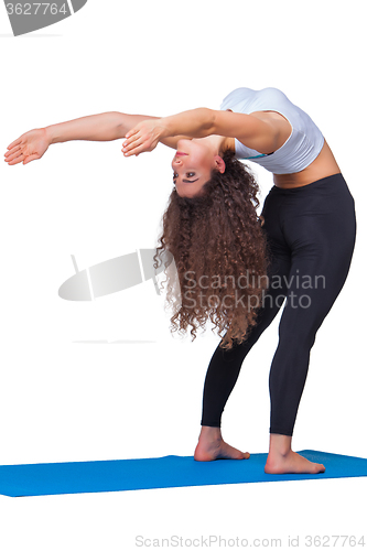 Image of Studio shot of a young fit woman doing yoga exercises.