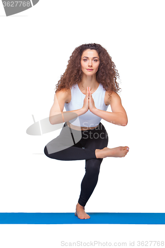 Image of Studio shot of a young fit woman doing yoga exercises.