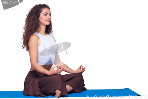 Image of Studio shot of a young fit woman doing yoga exercises.