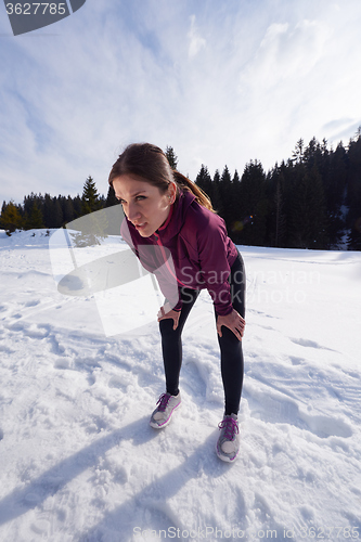 Image of yougn woman jogging outdoor on snow in forest