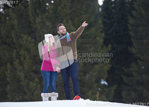 Image of couple having fun and walking in snow shoes